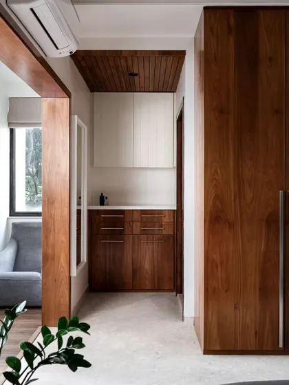 This image shows a passage leading into a bedroom, featuring beautiful wood paneling and custom wardrobes. Whether you call it a dressing room or a walk-in wardrobe, it's all about creating smart, seamless storage solutions.