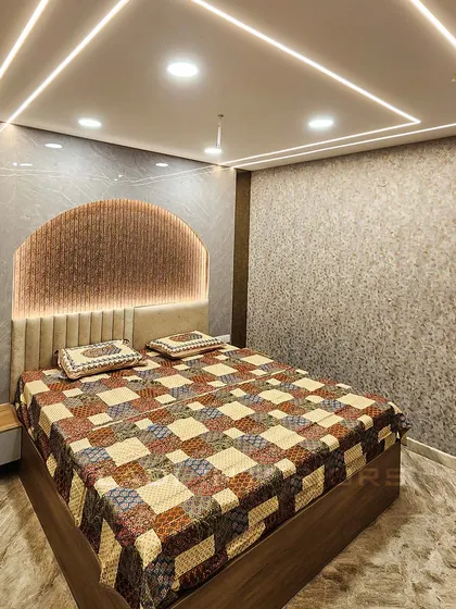 This bedroom features a unique arched headboard with fluted paneling and backlighting. The design is complemented by geometric LED strip lights on the ceiling, adding a modern and dynamic touch.