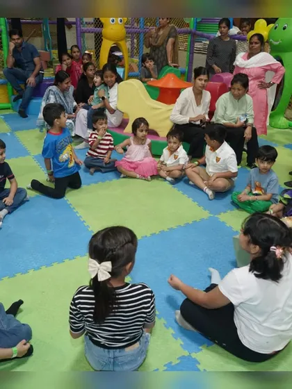 A group of children gathered for story time or a group game during a summer holiday visit.