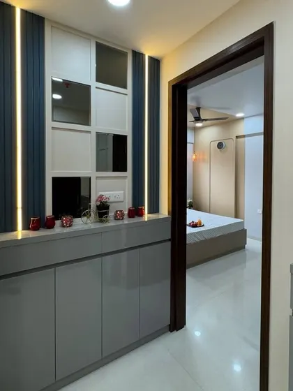 A close-up of the entryway storage unit, highlighting the clean lines, high-gloss finish, and the decorative items on top.