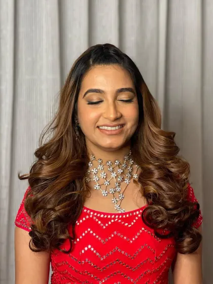 A happy smile from a client who feels amazing. The voluminous curls are the perfect party hairstyle.
