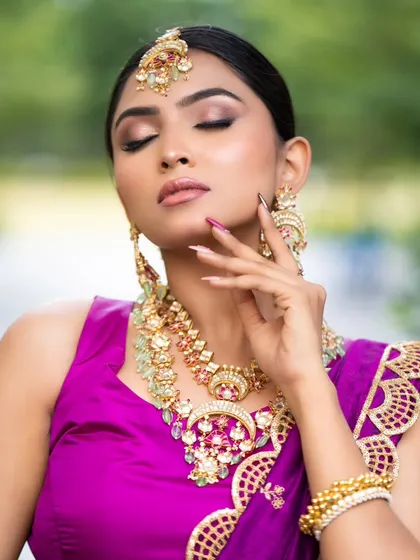 A beauty shot focusing on the flawless makeup and statement jewelry paired with our purple lehenga. Our full styling service ensures your hair and makeup are perfectly in sync with your outfit.