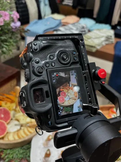 Another perspective from the Guess event photoshoot. This shot shows the camera capturing the vibrant colors of the grapefruit and cheeses on the platter, with the store's collection in the background.