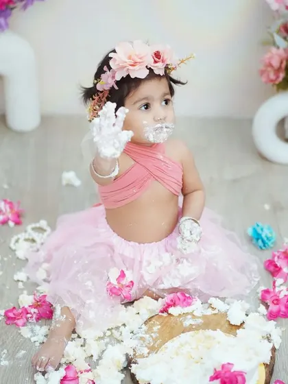 "Look what I did!" This photo perfectly captures the proud and playful aftermath of a successful cake smash.