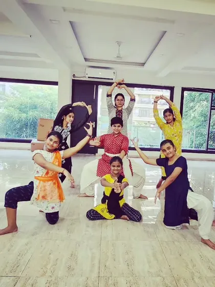 A group of our adult and teen students posing during a Bharatanatyam class, showcasing the diverse community at our studio.