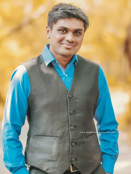 A confident and happy portrait of the groom-to-be, looking sharp in his waistcoat during their outdoor couple photoshoot.