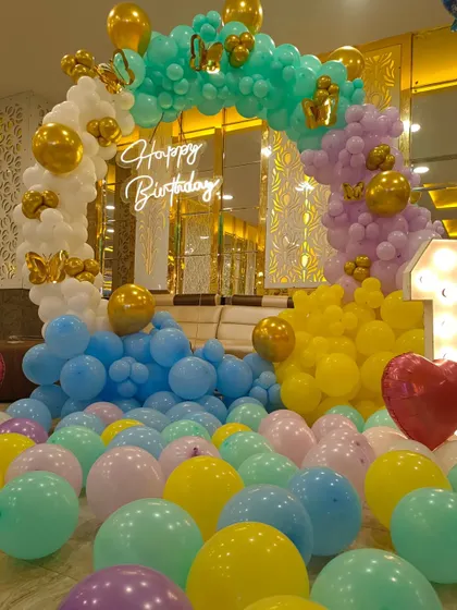 A grand balloon setup for a first birthday. The floor is filled with pastel balloons, creating a playful and immersive experience for the little one and guests.