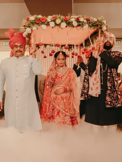 The bride makes her grand entrance under a 'phoolon ki chadar', walking through a cloud of smoke.