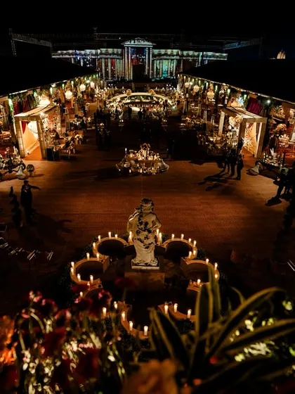 An overhead view of the garden and entryway, showing the Roman statues and candle-lit pathways. The design was intended to captivate guests with its magnitude and historical grandeur from the very first step.