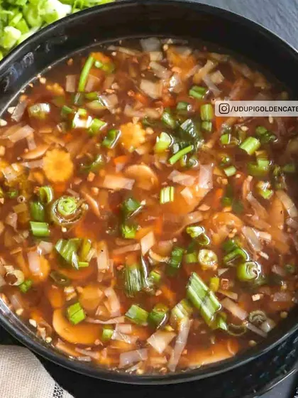 This is our Hot and Sour style soup, packed with vegetables and spring onions in a savory broth. It offers a perfect balance of spicy and tangy flavors.