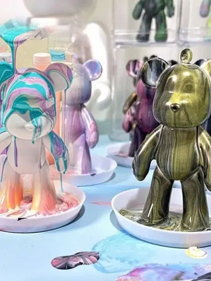 Watch the magic happen! This is the moment where you pour your custom-mixed colors over the bear and see your unique design come to life. I love guiding people through this super satisfying part of the fluid art process.