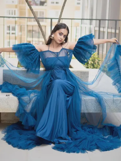 The full view of this artistic blue gown shows off its incredible design and flowing train. It's a wearable piece of art.