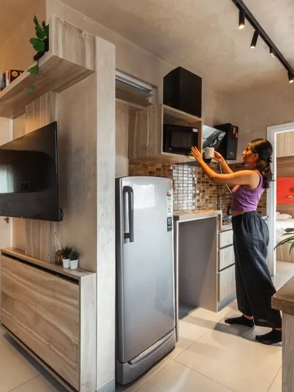 We turned the passage leading to the bedroom into a functional galley kitchen. This strategic layout decision frees up valuable area in the main living space, creating a more open and expansive feel throughout the apartment while keeping the kitchen easily accessible.