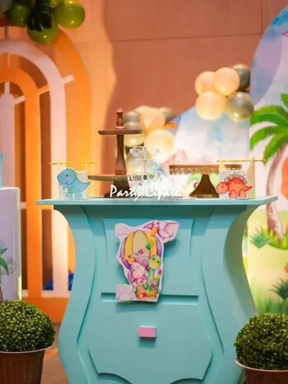 A detailed shot of the dino dessert table, with the cake, cupcakes, and custom props all arranged to create a delightful prehistoric scene.