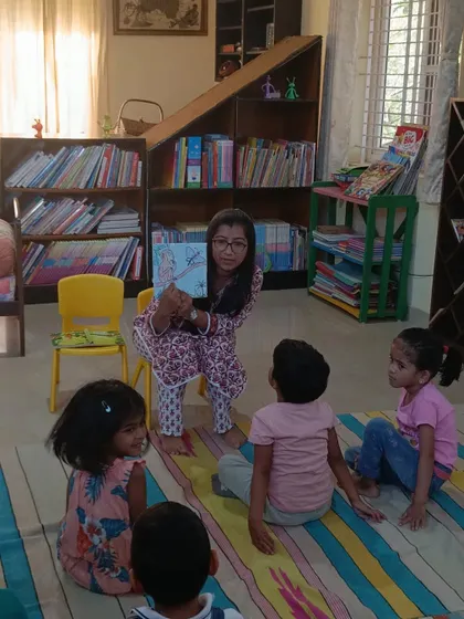 A storyteller uses a book with vivid illustrations to tell a tale about a monkey and a kind butterfly. The visuals are key to holding the attention of our youngest members.