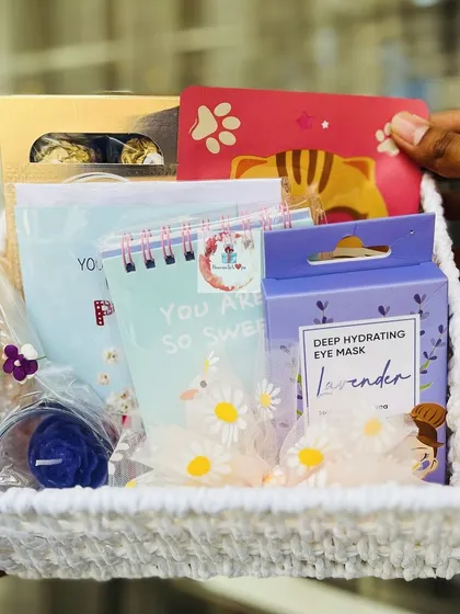 A sweet and simple Valentine's gift basket. This woven basket is filled with a hydrating eye mask, a cute notebook, and other small, thoughtful treats.