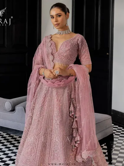 A symphony of blush tones and intricate hand-embroidery. This ethereal lehenga from the 'Ruvaah' collection redefines bridal elegance with its plunging neckline and delicate sequin detailing.
