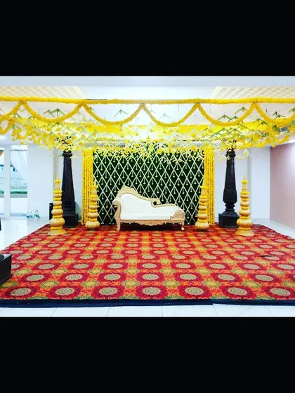 This image shows the full setup of the indoor traditional mandap. The ornate white chaise lounge adds a touch of modern comfort to the otherwise classic decor.