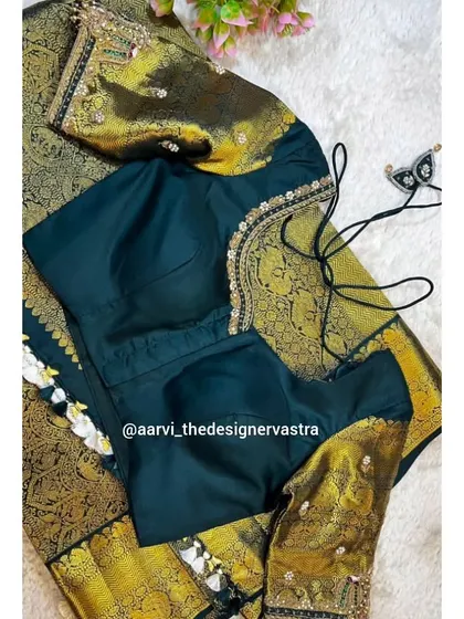 The front view of the dark green blouse, showing the simple yet elegant neckline and the rich brocade sleeves.