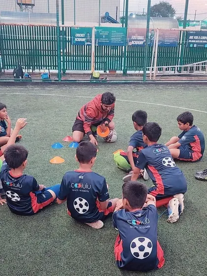 Tactical talk time. A coach sits with our young players in a circle, discussing game plans and strategies in an interactive and engaging way.