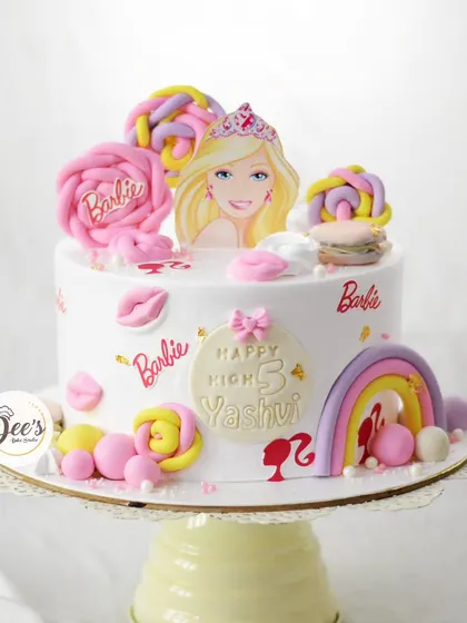 Come on Barbie, let's go party. This chic Barbie cake is decorated with lollipops, macarons, and iconic Barbie silhouettes for a stylish 3rd birthday.