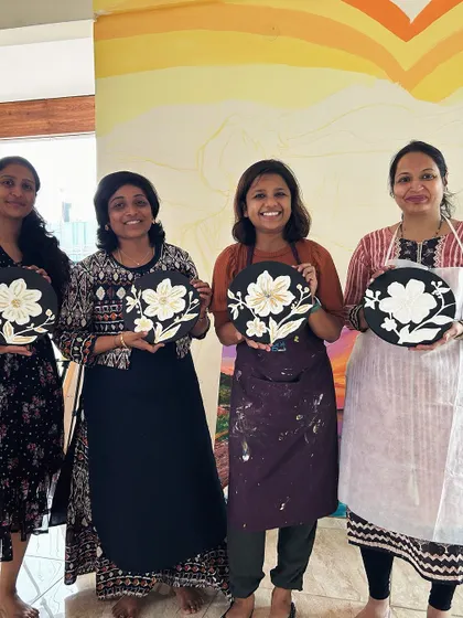 A group of artists with their finished textured gold leaf floral plates. The contrast of black, white, and gold is so chic.