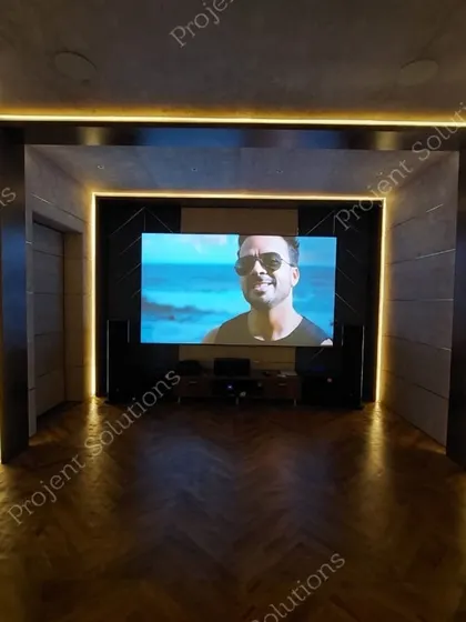 Our designs seamlessly blend with your home's interior. This theater features a clean, modern aesthetic with herringbone wood flooring and architectural LED lighting that frames the viewing area, housing a high-performance audio-visual system.