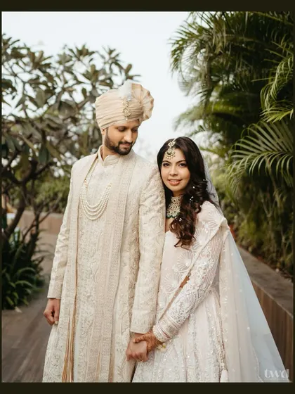 A classic and elegant portrait of the couple. They stand together, holding hands, radiating a quiet confidence and deep affection for one another.