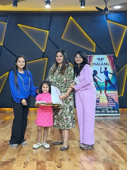 A young student proudly holds her certificate. These moments of recognition are a key part of our program, making every child feel special and accomplished.