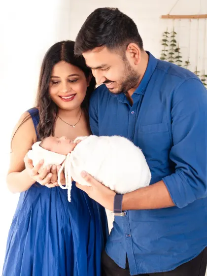 A loving gaze between new parents as they hold their baby. A beautiful portrait of a family's beginning.