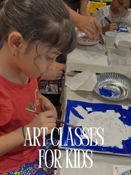 A young girl is deeply focused on painting a large canvas during one of my art classes designed specifically for kids.