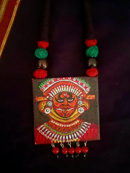 A duplicate image of the close-up Theyyam pendant.
