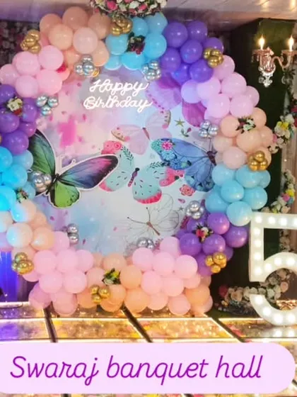 A magical Disney Princess theme for a 5th birthday party. The stage is decorated with a pastel balloon arch and cutouts of Cinderella, Ariel, and other princesses.