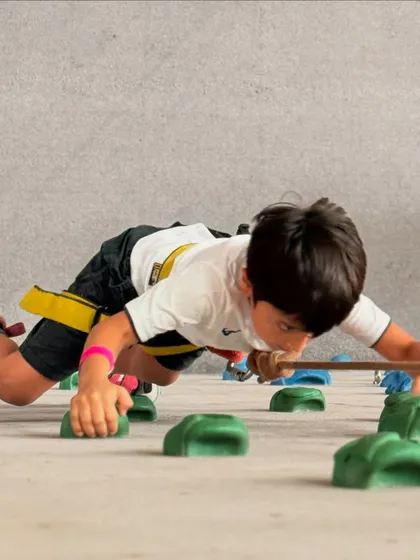 This young climber tackles a horizontal traverse, a fun challenge that builds strength and technique without the fear of heights. It's a great starting point for our youngest adventurers.