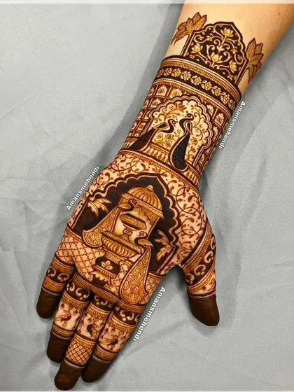 A rich design featuring a peacock and a fountain on the palm. The wrist is adorned with another peacock in a jharokha, creating a cohesive and elegant theme.