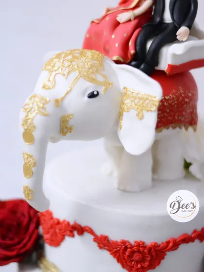 A close-up of the hand-sculpted fondant elephant, detailed with edible gold paint. Creating stable, intricate toppers like this is one of the most challenging and rewarding parts of my job.