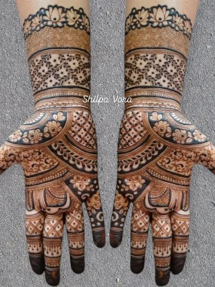 A symmetrical design with a floral wristband and a mix of geometric and leaf patterns on the hand.