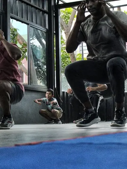 The team doing synchronized squats. Leg power is the source of a knockout punch, and we build it from the ground up.
