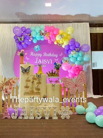 A vibrant butterfly theme with a purple backdrop and a colorful balloon arrangement.