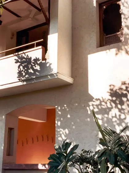 The play of light and shadow on the Ayushakti resort's facade, created by the building's articulated form with recessed arches and projecting balconies.