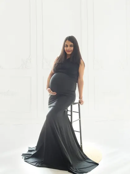 Wrapped in the elegance of black and white, this portrait celebrates the beauty of new life with grace and strength against a clean, minimalist backdrop.