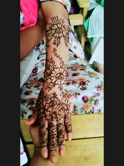 A full-arm floral vine design. This pattern gracefully winds its way from the hand to the elbow, perfect for someone who wants a longer, statement mehendi piece.