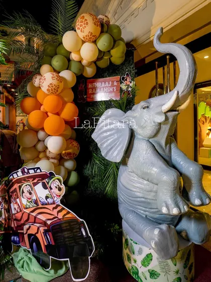 A fun photo corner with a large elephant statue and a cutout of Mickey and Goofy in a safari jeep, providing a playful spot for pictures.