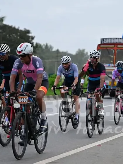 The masters peloton, with a support truck in the background, highlighting the logistical support we provide for a safe race.