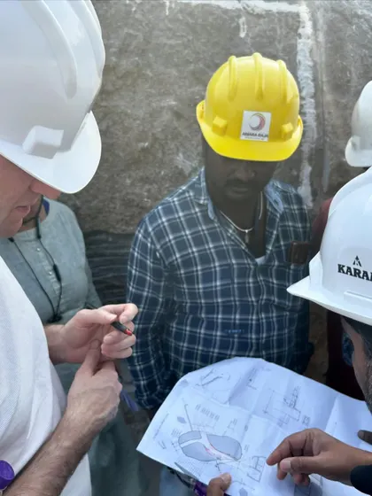 Our team marking cutouts on the main boulder at the Lurra House site. This intricate process involves translating our 2D drawings onto the 3D form of the natural rock.