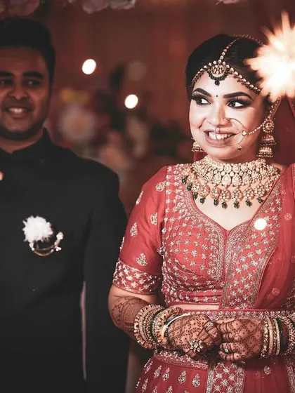 The bride's entrance is always a magical moment. Here, she walks in with a sparkling phuljhadi, her smile lighting up the frame as she makes her way to the stage.