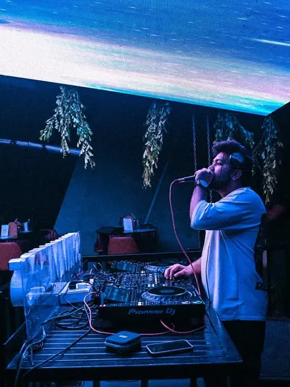 On the mic under the blue lights. I love to guide the crowd through the musical journey of my set.