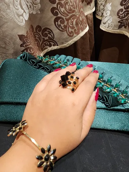 Getting ready for Diwali with the right accessories. This shot features a beautiful teal clutch with green embellishments, paired with a floral bracelet and ring.