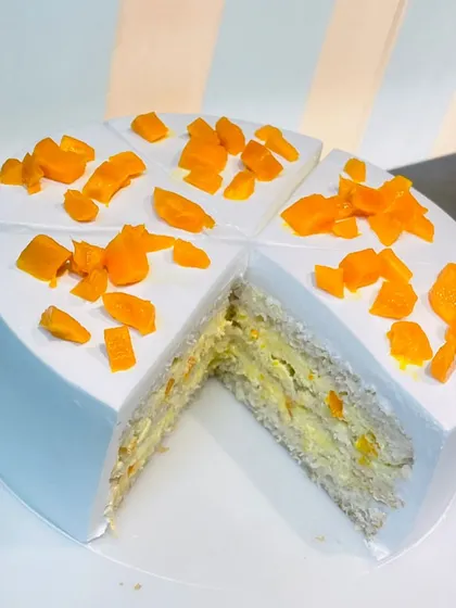 A slice of heaven! This image reveals the inside of our mango cake, with layers of light sponge and creamy mango filling.