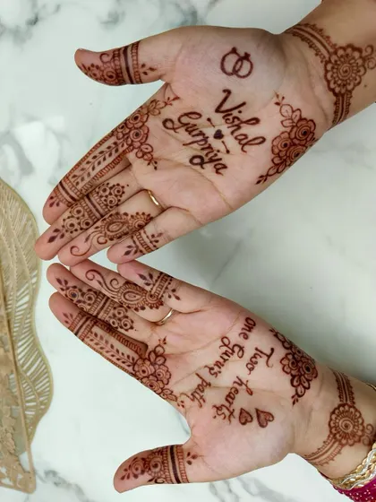 A different perspective of Gurpriya's engagement mehendi, highlighting the finger details and floral work.